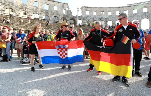 12.10.2022., Pula - Arena. Sluzbeno otvorenje svjetskog prvenstva u stolnom tenisu za osobe s dijagnozom Parkinsona koje se ove godine prema odluci neprofitne organizacije PingPongParkinson​ i partnera – Medjunarodne stolnoteniske federacije (ITTF) i Hrvatskog stolnoteniskog saveza, odrzava u Puli odnosno u Domu sportova Mate Parlov. Na svjetskom prvenstvu, koje ce trajati od 12. do 16. listopada 2022., ocekuje se vise od 400 sudionika, clanova pratnje i natjecatelja iz 22 drzave svijeta.
Pokretac ovog prvenstva je neprofitna americka zaklada PingPongParkinson​, kojoj je na celu hrvatsko-americki glazbenik Nenad Bach, izvodjac, producent i mirovni aktivist, i sam obolio od Parkinsona. Iako su lijekovi i dalje nezaobilazni u lijecenju, istrazivanja pokazuju kako sport, a posebice stolni tenis, pomaze u poboljsanju motorike kod ove dijagnoze.