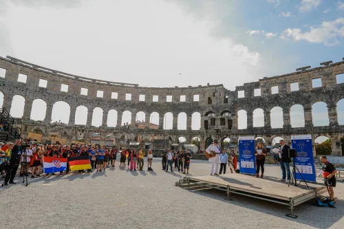12.10.2022., Pula - Arena. Sluzbeno otvorenje svjetskog prvenstva u stolnom tenisu za osobe s dijagnozom Parkinsona koje se ove godine prema odluci neprofitne organizacije PingPongParkinson​ i partnera – Medjunarodne stolnoteniske federacije (ITTF) i Hrvatskog stolnoteniskog saveza, odrzava u Puli odnosno u Domu sportova Mate Parlov. Na svjetskom prvenstvu, koje ce trajati od 12. do 16. listopada 2022., ocekuje se vise od 400 sudionika, clanova pratnje i natjecatelja iz 22 drzave svijeta.
Pokretac ovog prvenstva je neprofitna americka zaklada PingPongParkinson​, kojoj je na celu hrvatsko-americki glazbenik Nenad Bach, izvodjac, producent i mirovni aktivist, i sam obolio od Parkinsona. Iako su lijekovi i dalje nezaobilazni u lijecenju, istrazivanja pokazuju kako sport, a posebice stolni tenis, pomaze u poboljsanju motorike kod ove dijagnoze.