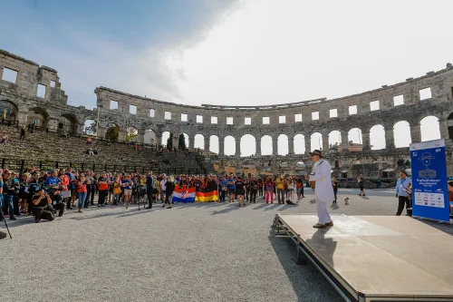 12.10.2022., Pula - Arena. Sluzbeno otvorenje svjetskog prvenstva u stolnom tenisu za osobe s dijagnozom Parkinsona koje se ove godine prema odluci neprofitne organizacije PingPongParkinson​ i partnera – Medjunarodne stolnoteniske federacije (ITTF) i Hrvatskog stolnoteniskog saveza, odrzava u Puli odnosno u Domu sportova Mate Parlov. Na svjetskom prvenstvu, koje ce trajati od 12. do 16. listopada 2022., ocekuje se vise od 400 sudionika, clanova pratnje i natjecatelja iz 22 drzave svijeta.
Pokretac ovog prvenstva je neprofitna americka zaklada PingPongParkinson​, kojoj je na celu hrvatsko-americki glazbenik Nenad Bach, izvodjac, producent i mirovni aktivist, i sam obolio od Parkinsona. Iako su lijekovi i dalje nezaobilazni u lijecenju, istrazivanja pokazuju kako sport, a posebice stolni tenis, pomaze u poboljsanju motorike kod ove dijagnoze.