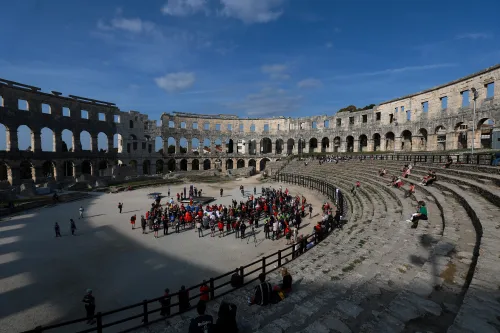 12.10.2022., Pula - Arena. Sluzbeno otvorenje svjetskog prvenstva u stolnom tenisu za osobe s dijagnozom Parkinsona koje se ove godine prema odluci neprofitne organizacije PingPongParkinson​ i partnera – Medjunarodne stolnoteniske federacije (ITTF) i Hrvatskog stolnoteniskog saveza, odrzava u Puli odnosno u Domu sportova Mate Parlov. Na svjetskom prvenstvu, koje ce trajati od 12. do 16. listopada 2022., ocekuje se vise od 400 sudionika, clanova pratnje i natjecatelja iz 22 drzave svijeta.
Pokretac ovog prvenstva je neprofitna americka zaklada PingPongParkinson​, kojoj je na celu hrvatsko-americki glazbenik Nenad Bach, izvodjac, producent i mirovni aktivist, i sam obolio od Parkinsona. Iako su lijekovi i dalje nezaobilazni u lijecenju, istrazivanja pokazuju kako sport, a posebice stolni tenis, pomaze u poboljsanju motorike kod ove dijagnoze.