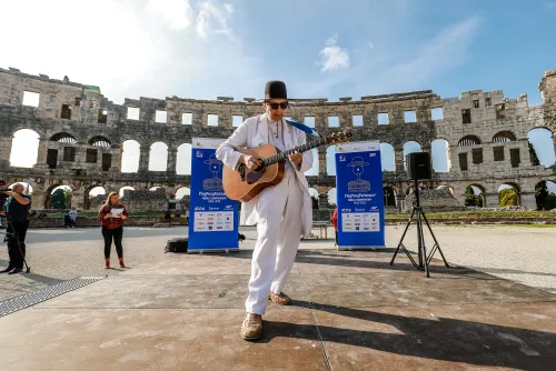 12.10.2022., Pula - Arena. Sluzbeno otvorenje svjetskog prvenstva u stolnom tenisu za osobe s dijagnozom Parkinsona koje se ove godine prema odluci neprofitne organizacije PingPongParkinson​ i partnera – Medjunarodne stolnoteniske federacije (ITTF) i Hrvatskog stolnoteniskog saveza, odrzava u Puli odnosno u Domu sportova Mate Parlov. Na svjetskom prvenstvu, koje ce trajati od 12. do 16. listopada 2022., ocekuje se vise od 400 sudionika, clanova pratnje i natjecatelja iz 22 drzave svijeta.
Pokretac ovog prvenstva je neprofitna americka zaklada PingPongParkinson​, kojoj je na celu hrvatsko-americki glazbenik Nenad Bach, izvodjac, producent i mirovni aktivist, i sam obolio od Parkinsona. Iako su lijekovi i dalje nezaobilazni u lijecenju, istrazivanja pokazuju kako sport, a posebice stolni tenis, pomaze u poboljsanju motorike kod ove dijagnoze.
