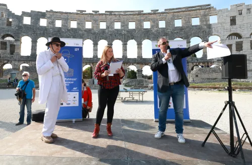 12.10.2022., Pula - Arena. Sluzbeno otvorenje svjetskog prvenstva u stolnom tenisu za osobe s dijagnozom Parkinsona koje se ove godine prema odluci neprofitne organizacije PingPongParkinson​ i partnera – Medjunarodne stolnoteniske federacije (ITTF) i Hrvatskog stolnoteniskog saveza, odrzava u Puli odnosno u Domu sportova Mate Parlov. Na svjetskom prvenstvu, koje ce trajati od 12. do 16. listopada 2022., ocekuje se vise od 400 sudionika, clanova pratnje i natjecatelja iz 22 drzave svijeta.
Pokretac ovog prvenstva je neprofitna americka zaklada PingPongParkinson​, kojoj je na celu hrvatsko-americki glazbenik Nenad Bach, izvodjac, producent i mirovni aktivist, i sam obolio od Parkinsona. Iako su lijekovi i dalje nezaobilazni u lijecenju, istrazivanja pokazuju kako sport, a posebice stolni tenis, pomaze u poboljsanju motorike kod ove dijagnoze.